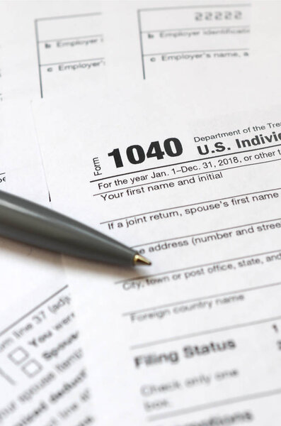 The pen lies on the tax form 1040 U.S. Individual Income Tax Return. The time to pay taxes