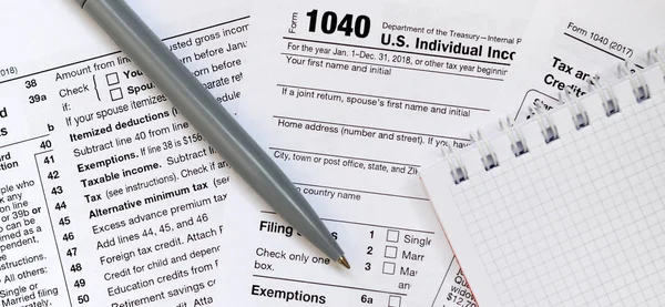 ペンとノートは 税上にあるフォーム 1040 米国個人所得税申告書です 税金を払うために時間 — ストック写真
