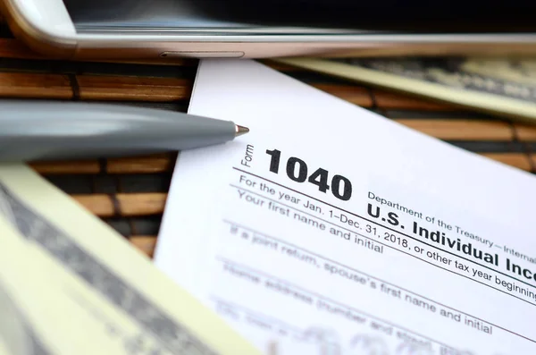 笔记本 智能手机和美元钞票是在税收形式1040美国个人所得税申报表 纳税时间 — 图库照片