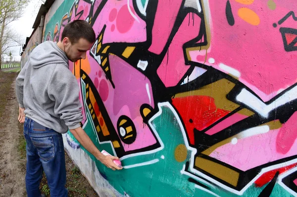 Joven Con Capucha Gris Pinta Graffiti Colores Rosa Verde Una —  Fotos de Stock