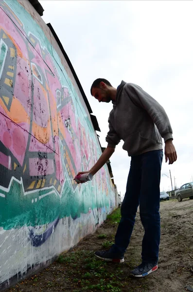 Joven Con Capucha Gris Pinta Graffiti Colores Rosa Verde Una —  Fotos de Stock