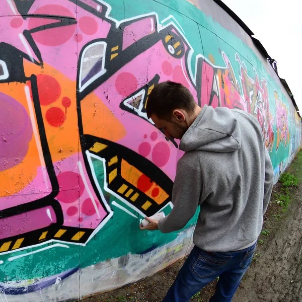 Joven Con Capucha Gris Pinta Graffiti Colores Rosa Verde Una —  Fotos de Stock