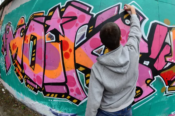 Young Guy Gray Hoodie Paints Graffiti Pink Green Colors Wall — Stock Photo, Image