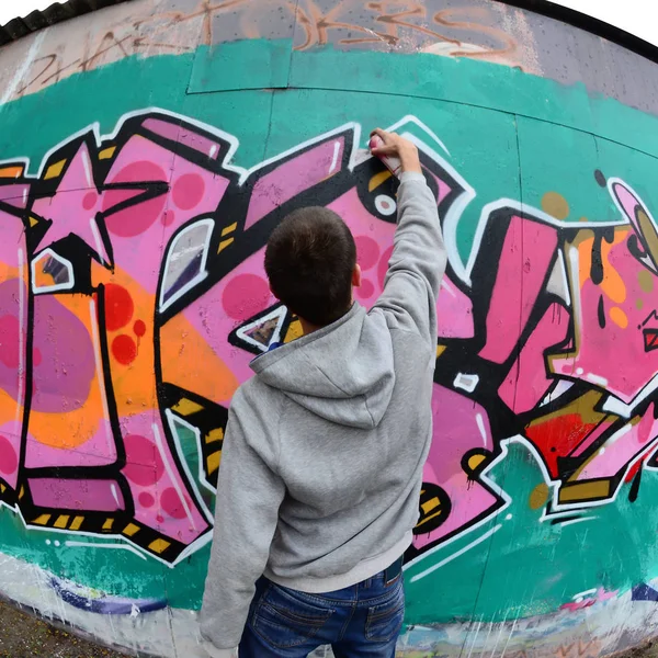 Joven Con Capucha Gris Pinta Graffiti Colores Rosa Verde Una —  Fotos de Stock