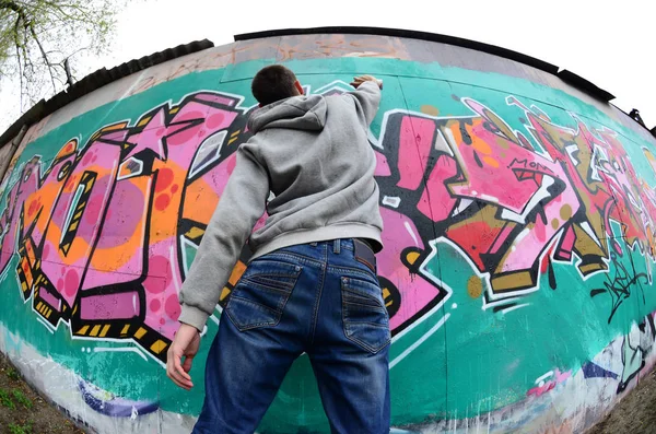 Egy Fiatal Srác Egy Szürke Kapucnis Fest Graffiti Falon Rózsaszín — Stock Fotó