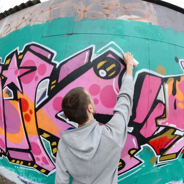 Young Guy Gray Hoodie Paints Graffiti Pink Green Colors Wall — Stock Photo, Image