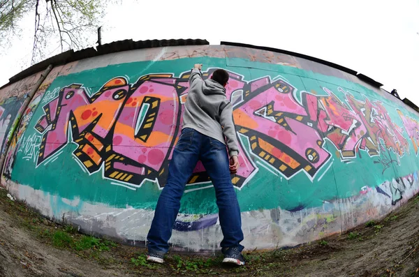 Joven Con Capucha Gris Pinta Graffiti Colores Rosa Verde Una — Foto de Stock