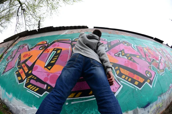Молодой Парень Серой Толстовке Рисует Граффити Розовым Зеленым Цветами Стене — стоковое фото