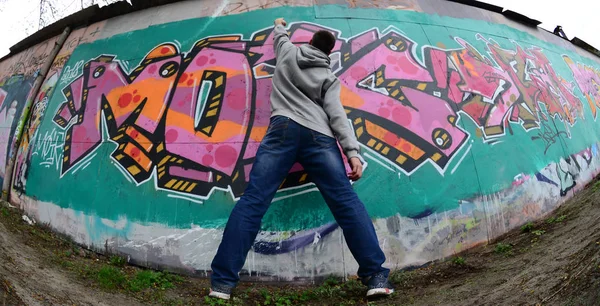 Młody Facet Szara Bluza Kapturem Maluje Graffiti Różowe Zielone Kolory — Zdjęcie stockowe