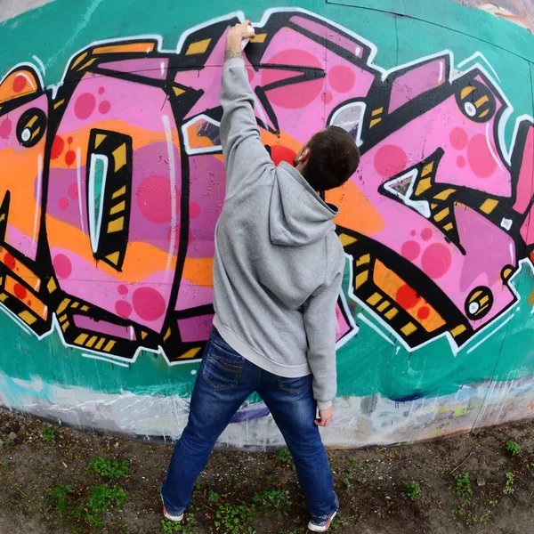 Joven Con Capucha Gris Pinta Graffiti Colores Rosa Verde Una — Foto de Stock