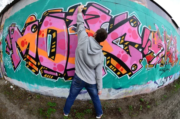 Ein Junger Mann Grauen Kapuzenpullover Malt Bei Regenwetter Graffiti Rosa — Stockfoto