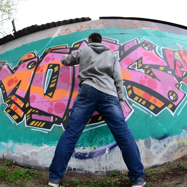 Joven Con Capucha Gris Pinta Graffiti Colores Rosa Verde Una — Foto de Stock