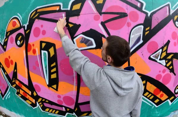 Joven Con Capucha Gris Pinta Graffiti Colores Rosa Verde Una — Foto de Stock