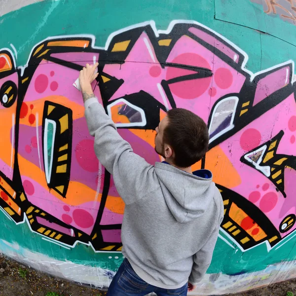 Joven Con Capucha Gris Pinta Graffiti Colores Rosa Verde Una —  Fotos de Stock