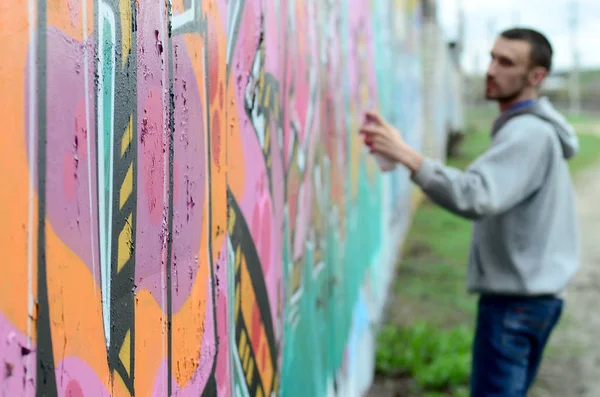 Jonge Kerel Een Grijze Hoodie Schildert Graffiti Roze Groene Kleuren — Stockfoto