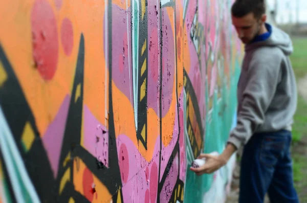 Jonge Kerel Een Grijze Hoodie Schildert Graffiti Roze Groene Kleuren — Stockfoto