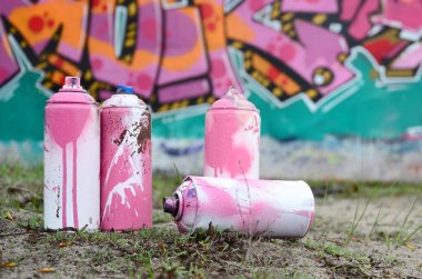 Güzel grafiti resmi bulunan bir rahiplik pembe ve yeşil renkleri ile duvarın yanında yere birkaç kullanılan boya... kutularını yalan. Sokak sanatı kavramı