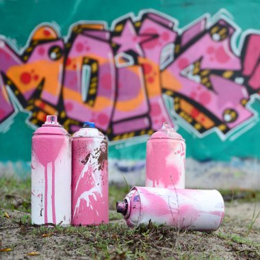 Güzel grafiti resmi bulunan bir rahiplik pembe ve yeşil renkleri ile duvarın yanında yere birkaç kullanılan boya... kutularını yalan. Sokak sanatı kavramı