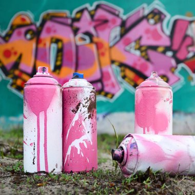 Güzel grafiti resmi bulunan bir rahiplik pembe ve yeşil renkleri ile duvarın yanında yere birkaç kullanılan boya... kutularını yalan. Sokak sanatı kavramı