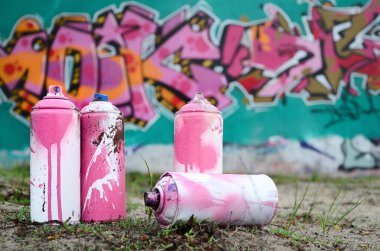 Güzel grafiti resmi bulunan bir rahiplik pembe ve yeşil renkleri ile duvarın yanında yere birkaç kullanılan boya... kutularını yalan. Sokak sanatı kavramı