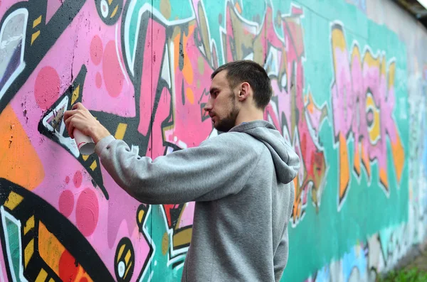 Een Jonge Man Een Grijze Hoodie Schildert Graffiti Roze Groene — Stockfoto