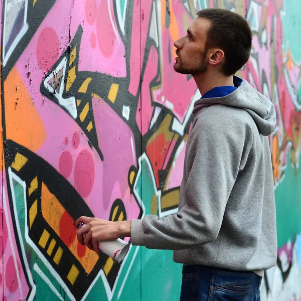 Ein Junger Mann Grauen Kapuzenpullover Malt Bei Regenwetter Graffiti Rosa — Stockfoto