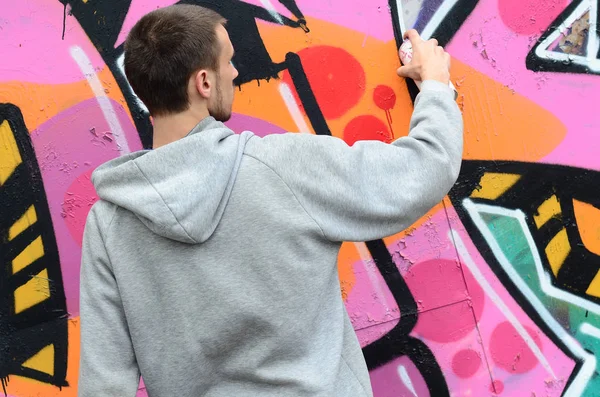 Joven Con Capucha Gris Pinta Graffiti Colores Rosa Verde Una — Foto de Stock