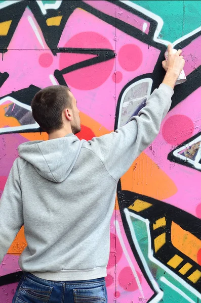 Joven Con Capucha Gris Pinta Graffiti Colores Rosa Verde Una — Foto de Stock