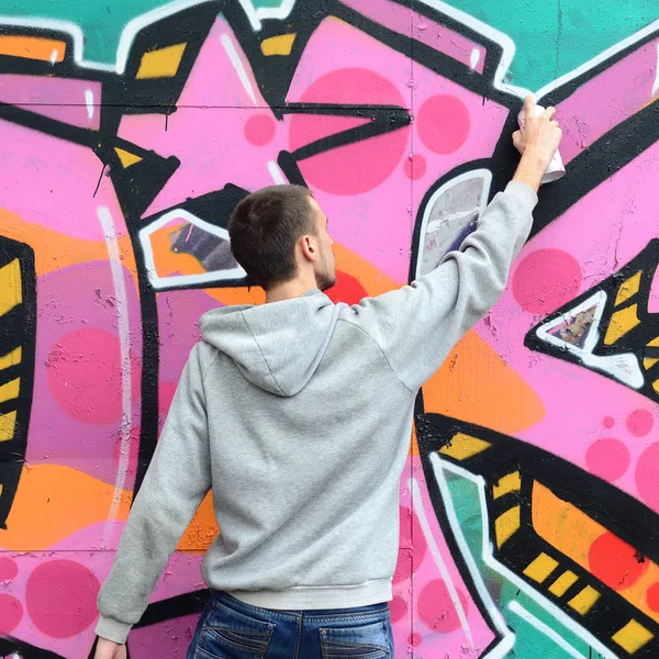 Een Jonge Man Een Grijze Hoodie Schildert Graffiti Roze Groene — Stockfoto
