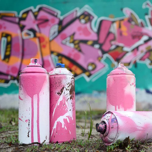 一些二手油漆罐躺在墙边的地面上 用粉红色和绿色的颜色画出美丽的涂鸦 街道艺术概念 — 图库照片