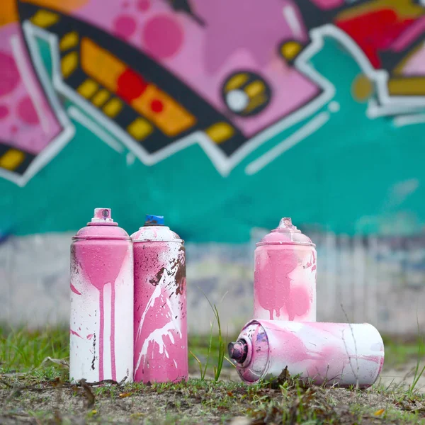 Alcune lattine di vernice usate giacciono a terra vicino al muro con una bea — Foto Stock