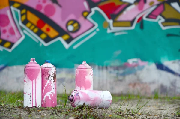 A few used paint cans lie on the ground near the wall with a bea — Stock Photo, Image
