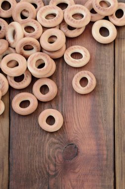 Bir sürü taze sarı simit eski koyu renkli ahşap yüzeyde yalan. Unlu Mamüller popüler bir tür. Bir geleneksel Rus Çay için davranır