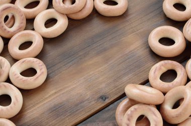 Bir sürü taze sarı simit eski koyu renkli ahşap yüzeyde yalan. Unlu Mamüller popüler bir tür. Bir geleneksel Rus Çay için davranır