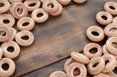 Bir sürü taze sarı simit eski koyu renkli ahşap yüzeyde yalan. Unlu Mamüller popüler bir tür. Bir geleneksel Rus Çay için davranır