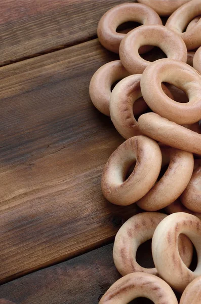 Una gran cantidad de bagels amarillos frescos se encuentran en la superficie de la vieja oscuridad —  Fotos de Stock