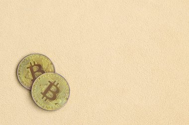 İki altın bitcoins yumuşak ve kabarık ışık turuncu Polar kumaştan yapılmış bir battaniye yatıyor. Sanal kripto para biriminin fiziksel görselleştirme