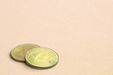 İki altın bitcoins yumuşak ve kabarık ışık turuncu Polar kumaştan yapılmış bir battaniye yatıyor. Sanal kripto para biriminin fiziksel görselleştirme