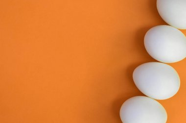 Bir kaç beyaz Paskalya yumurtaları parlak turuncu zemin