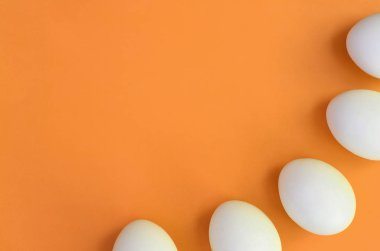 Bir kaç beyaz Paskalya yumurtaları parlak turuncu zemin