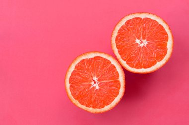 Pembe renkte parlak arka plan üzerinde üstten görünüm birkaç greyfurt dilim. Doymuş narenciye doku görüntü