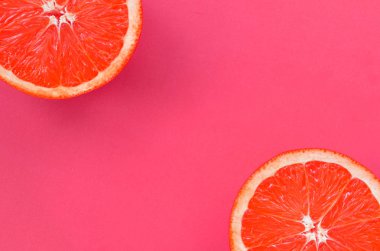 Pembe renkte parlak arka plan üzerinde üstten görünüm birkaç greyfurt dilim. Doymuş narenciye doku görüntü