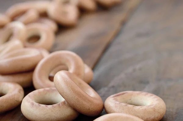 Una gran cantidad de bagels amarillos frescos se encuentran en la superficie de la vieja oscuridad —  Fotos de Stock