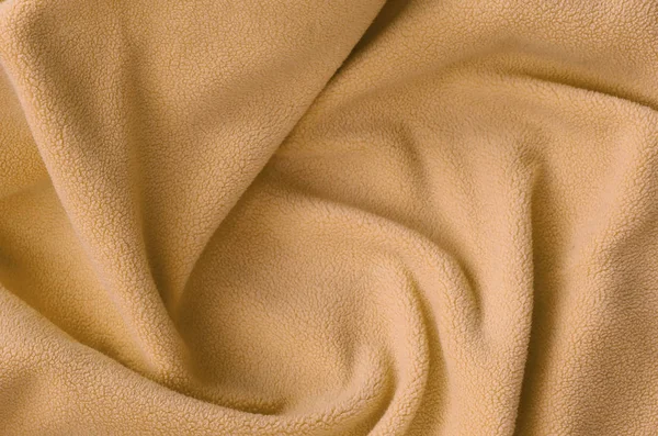 Η κουβέρτα γούνινο πορτοκαλί φλις ύφασμα. Ένα φόντο του υλικού φωτός πορτοκαλί μαλακό φλις φούτερ με πολλή ανακούφιση πτυχώσεις — Φωτογραφία Αρχείου