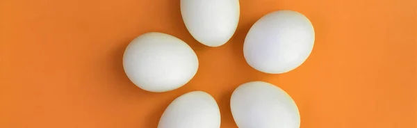 Pár bílých velikonoční vajíčka na zářivě oranžové pozadí — Stock fotografie