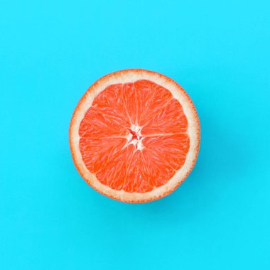 Mavi renkte parlak arka plan üzerinde üstten görünüm bir greyfurt dilim. Doymuş narenciye doku görüntü