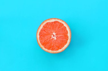 Mavi renkte parlak arka plan üzerinde üstten görünüm bir greyfurt dilim. Doymuş narenciye doku görüntü