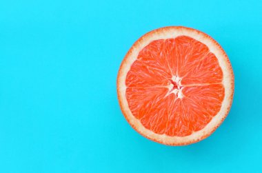 Mavi renkte parlak arka plan üzerinde üstten görünüm bir greyfurt dilim. Doymuş narenciye doku görüntü