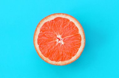 Mavi renkte parlak arka plan üzerinde üstten görünüm bir greyfurt dilim. Doymuş narenciye doku görüntü