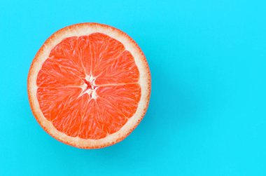 Mavi renkte parlak arka plan üzerinde üstten görünüm bir greyfurt dilim. Doymuş narenciye doku görüntü